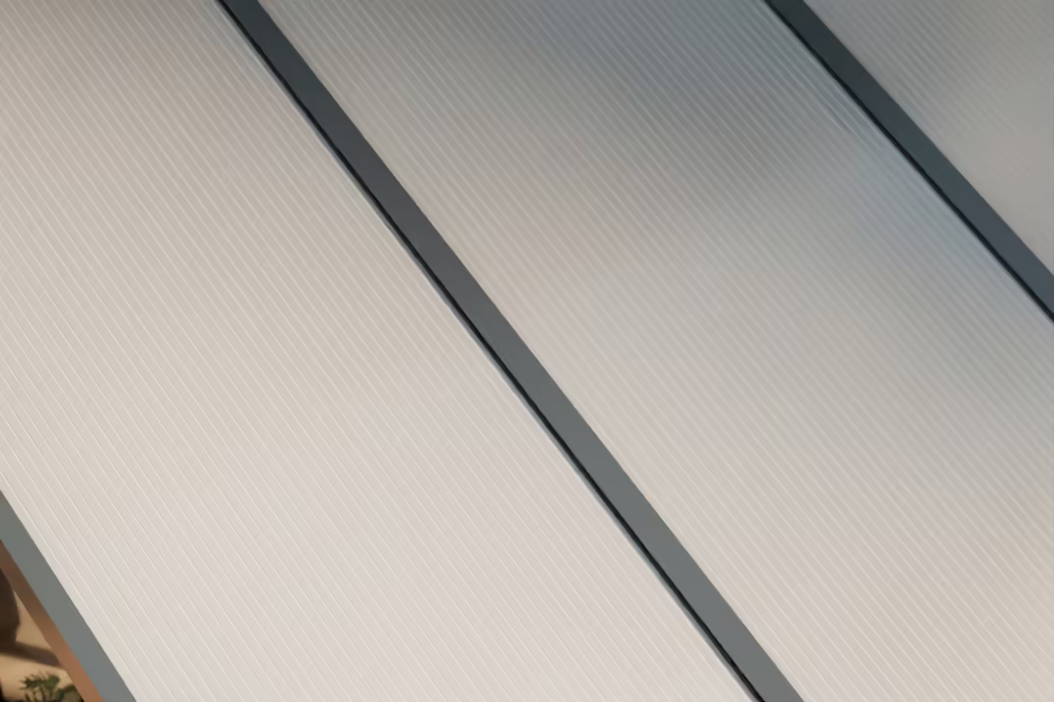 Terrassenüberdachung mit opalem Polycarbonatdach und anthrazitfarbenem Rahmen